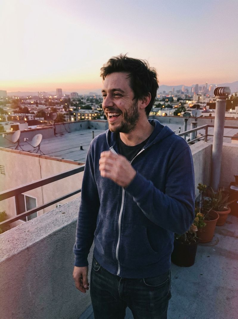Marcus, 29, an architect laughing on a rooftop at sunset — sample FoundLoveHere profile